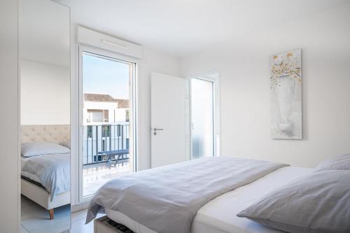 une chambre blanche avec un lit et un balcon dans l'établissement Via Marenda - Antibes Old Town Top Location and Free Parking, à Antibes