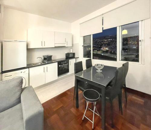 a kitchen and living room with a table and chairs at Charming House in Funchal with Sea View in Funchal