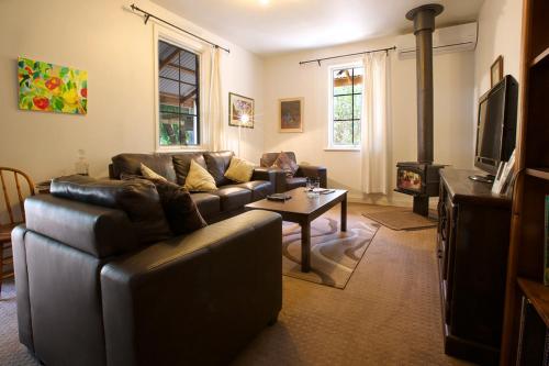 a living room with a leather couch and a fireplace at Amy's House Bed & Breakfast in Auburn
