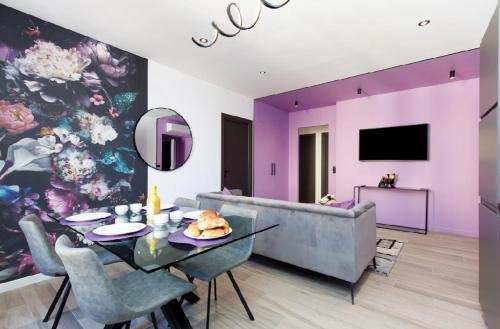 - un salon avec des murs violets, une table et un canapé dans l'établissement Somptueux 4 pièces Foch - Centre Cannes et proche Palais des Festivals, à Cannes