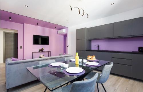 une salle à manger avec des murs violets, une table et des chaises dans l'établissement Somptueux 4 pièces Foch - Centre Cannes et proche Palais des Festivals, à Cannes
