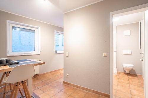 a bathroom with a toilet and a desk and a window at Stilvolle Wohlfühloase Andernach in Andernach