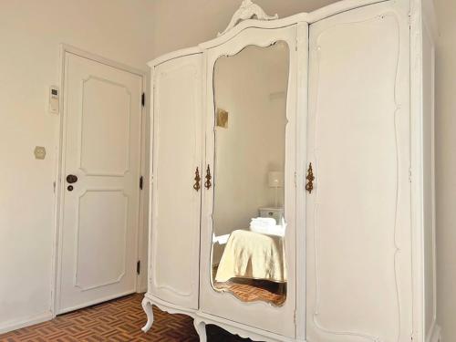 a white cabinet with a mirror in a room at Casa do Carmo Fuzeta by Junto ao Mar in Fuzeta