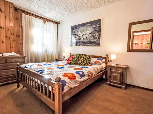 a bedroom with a bed and a dresser and a window at Apartment Casa Rossa by Interhome in Madesimo