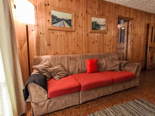 a brown couch with red pillows in a living room at Apartment Casa Rossa by Interhome in Madesimo