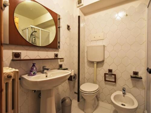 a bathroom with a sink and a toilet and a mirror at Apartment Casa Rossa by Interhome in Madesimo