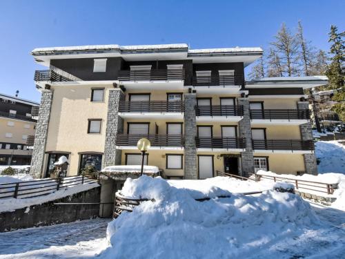 a building with a pile of snow in front of it at Apartment Tigli by Interhome in Madesimo