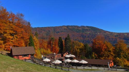 a building with umbrellas in front of a mountain at Chata Wuja Toma in Szczyrk