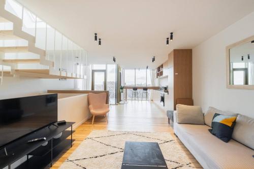 a living room with a couch and a staircase at Top Floor New Duplex Stunning View In Trendy St Gilles in Brussels