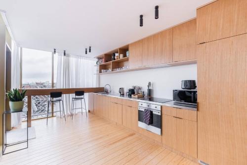 a kitchen with wooden cabinets and a counter top at Top Floor New Duplex Stunning View In Trendy St Gilles in Brussels