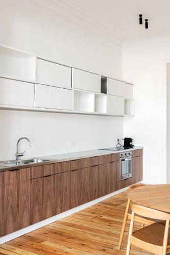 a kitchen with wooden cabinets and a wooden table at Top Floor New Duplex Stunning View In Trendy St Gilles in Brussels