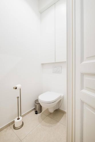 a white bathroom with a toilet and a door at Top Floor New Duplex Stunning View In Trendy St Gilles in Brussels