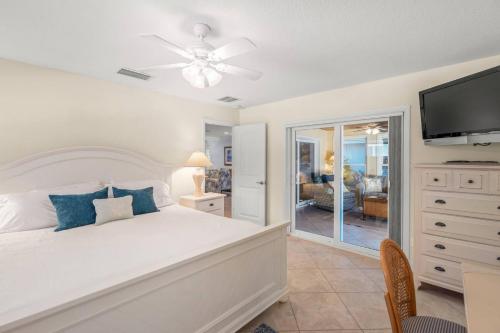 een slaapkamer met een bed en een flatscreen-tv bij Siesta Villa Whispering Palms in Siesta Key