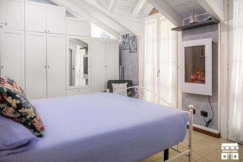 une chambre blanche avec un lit et une cheminée dans l'établissement M&P HOUSE by Design Studio, à Bellano