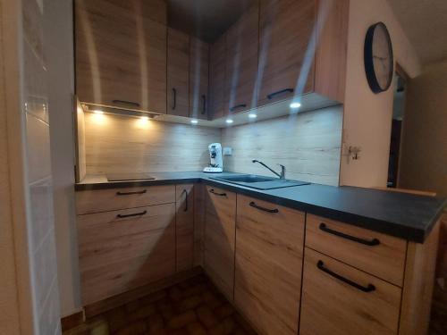 une cuisine avec des armoires en bois et un évier dans l'établissement Résidence BORA BORA, à Marseillan