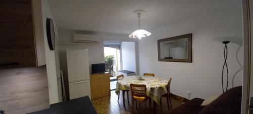 un salon avec une table et une cuisine dans l'établissement Résidence BORA BORA, à Marseillan