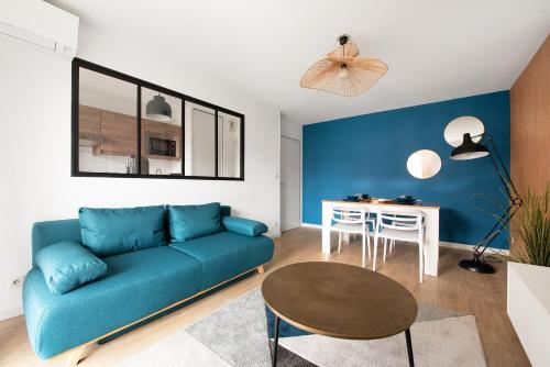 un salon avec un canapé bleu et une table dans l'établissement Chic T2 avec Balcon et Parking - Zénith, Hippodrome, à Toulouse