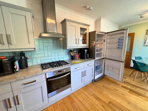 a kitchen with white cabinets and a stove top oven at Freeman Hot Tub House, Free Parking, Transport Links in Longbenton