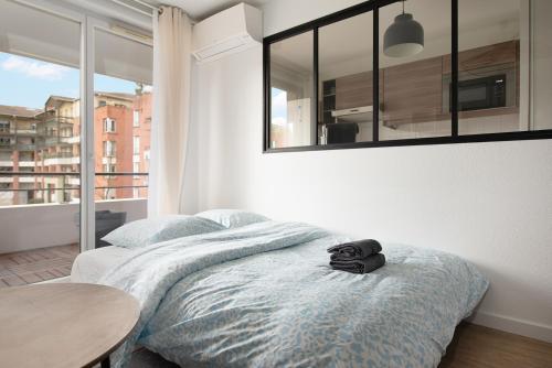 トゥールーズにあるChic T2 avec Balcon et Parking - Zénith, Hippodromeのベッドルーム1室(ベッド1台、バックパック付)
