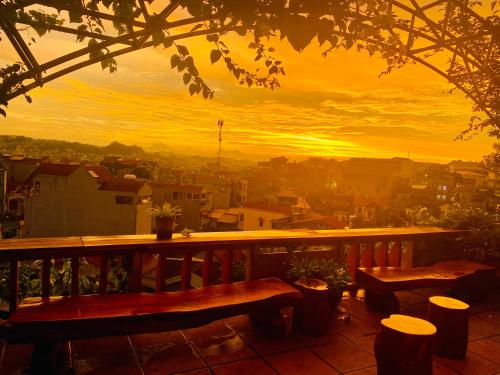 a view of a sunset from a balcony with benches at Kha Bản Homestay in Cao Bằng