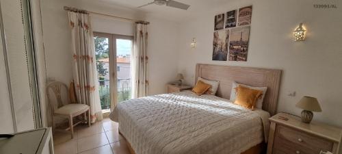 ein Schlafzimmer mit einem Bett und einem großen Fenster in der Unterkunft Pestana Carvoeiro Golfe - AL in Carvoeiro