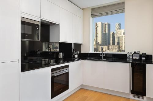 a kitchen with white cabinets and a view of a city at InterContinental London - The O2 in London
