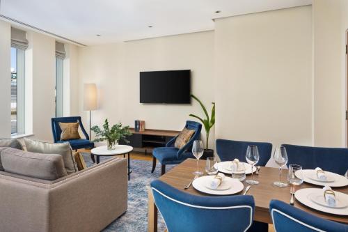 a dining room with a table and chairs and a tv at InterContinental London - The O2 in London