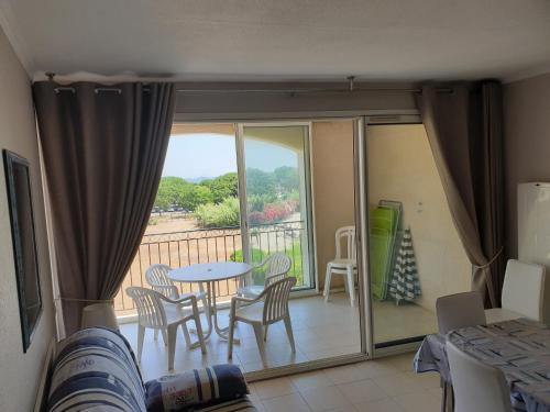 une chambre avec un balcon avec une table et des chaises dans l'établissement Les Marines de Gassin, à Gassin
