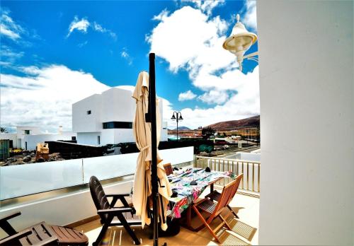 a patio with a table and chairs on a balcony at Evita Arrieta in Haría