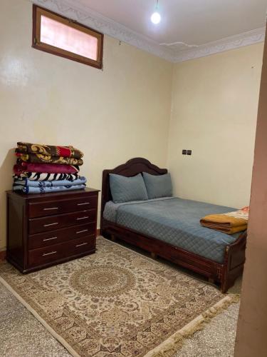 a bedroom with a bed and a dresser in it at Appartement meublé in Benguerir