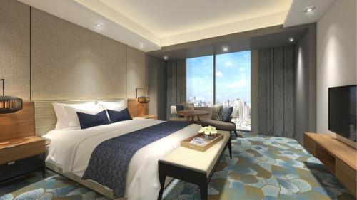 a hotel room with a bed and a television at Holiday Inn & Suites Penang Prai by IHG in Bukit Mertajam