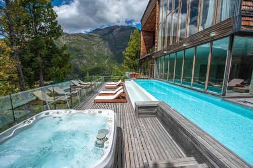 a bath tub sitting on a deck next to a building at Uman Lodge Patagonia Chile in Futaleufú
