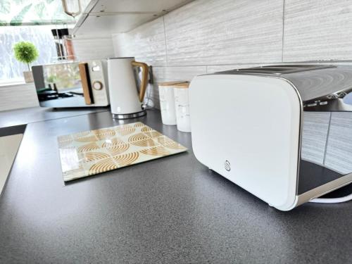 a toaster sitting on a counter in a kitchen at SHM Stays Solihull HS2 NEC Airport Nr M6 M40 M42 Great for Long & Short stays 15 min walk to Train Station 5 min drive to Town Centre outside Bus Stops & Supermarket Free Parking in Solihull