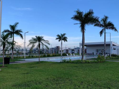 Un parque con palmeras y un edificio. en sophia by aby House, en San Miguel