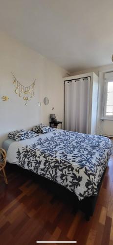 une chambre avec un lit avec une couverture bleue et blanche dans l'établissement Chez Val et Paul, à Vannes