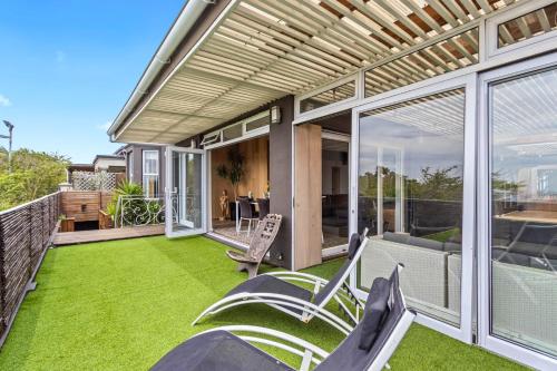 an outdoor patio with green grass and chairs at Exclusive 3-Bedroom Luxury Villa Cape Town CBD in Cape Town