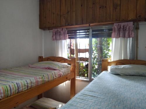 a bedroom with two bunk beds and a window at Los Duendes del Mar in San Clemente del Tuyú