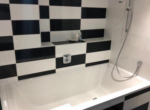 une salle de bain avec un mur à carreaux noir et blanc dans l'établissement Petite France - 4 pers, à Strasbourg