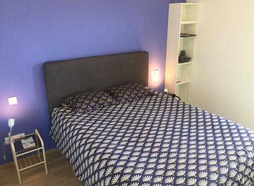 Ce lit se trouve dans une chambre dotée d'un mur violet. dans l'établissement Petite France - 4 pers, à Strasbourg