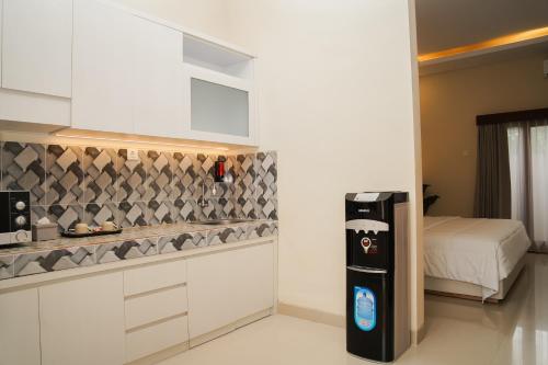 Una cocina con nevera y una cama en una habitación. en Gelis Gede Cottages, en Uluwatu