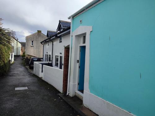 a row of houses with blue paint on a street at Dartmouth Diddy House in Dartmouth