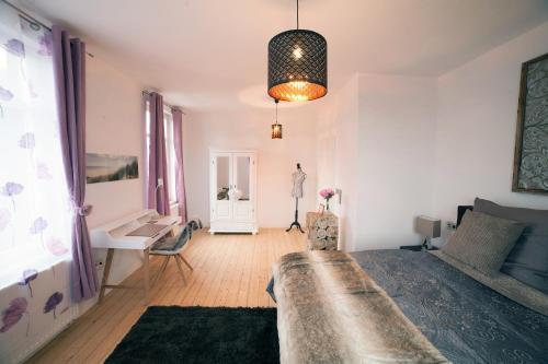 a bedroom with a bed and a table and a desk at DesignLodge Apartments in Bad Sobernheim