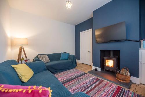 a living room with a couch and a fireplace at Culberry Cottage, Southwold in Southwold