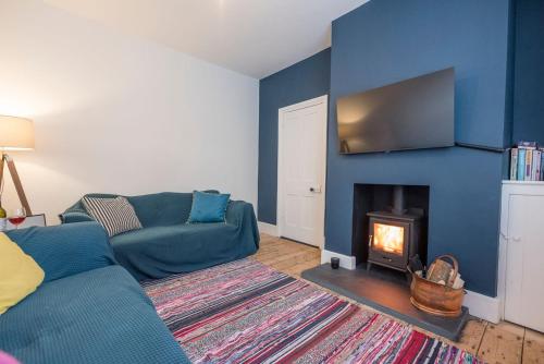 a living room with a couch and a fireplace at Culberry Cottage, Southwold in Southwold