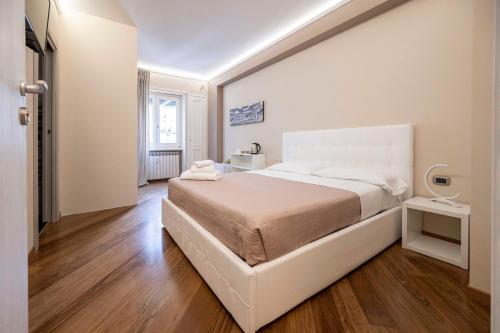 a white bedroom with a large white bed and wooden floors at Le stanze sui musei vaticani in Rome