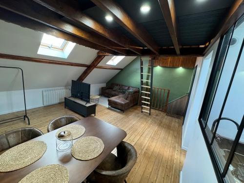 une pièce avec une table, des chaises et un canapé dans l'établissement Le Havre des toits - cosy tout équipé, à Boulogne-sur-Mer