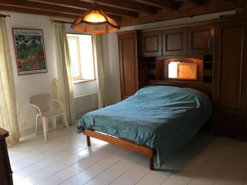 a bedroom with a bed with a blue comforter at Maison spacieuse tranquille et calme PMR possible in Cronce