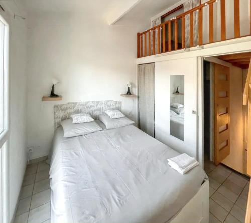 - une chambre blanche avec un grand lit blanc dans l'établissement Maison cosy à La Londe-les-Maures, proche plage, à La Londe-les-Maures