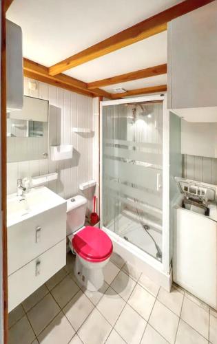 La salle de bains est pourvue d'une douche et de toilettes rouges. dans l'établissement Maison cosy à La Londe-les-Maures, proche plage, à La Londe-les-Maures