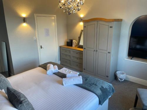 a bedroom with a bed with two towels on it at The Wildings Hotel & Tudno's Restaurant in Llandudno